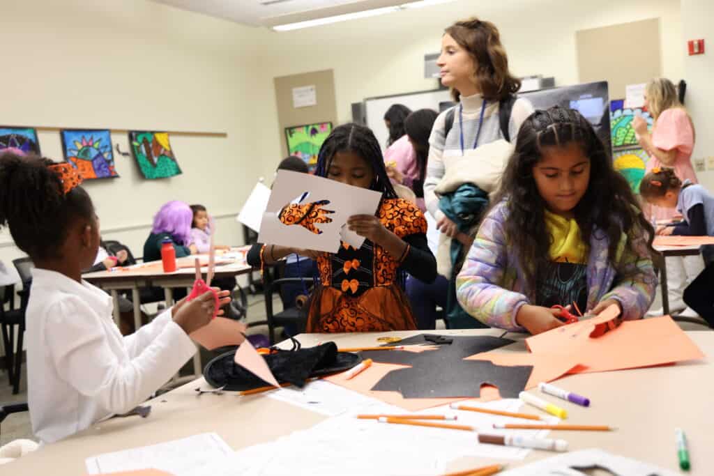 Photo of students cutting construction paper for arts and crafts