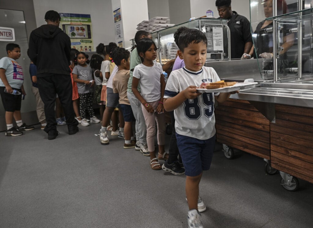 DCPS student holding up lunch tray of food