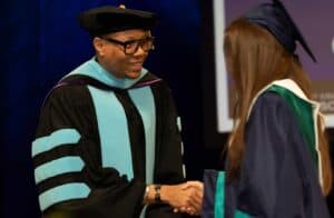 Graduate shaking hands with the Chancellor at graduation.