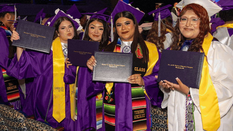 Graduation DCPS graduates holding diplomas.
